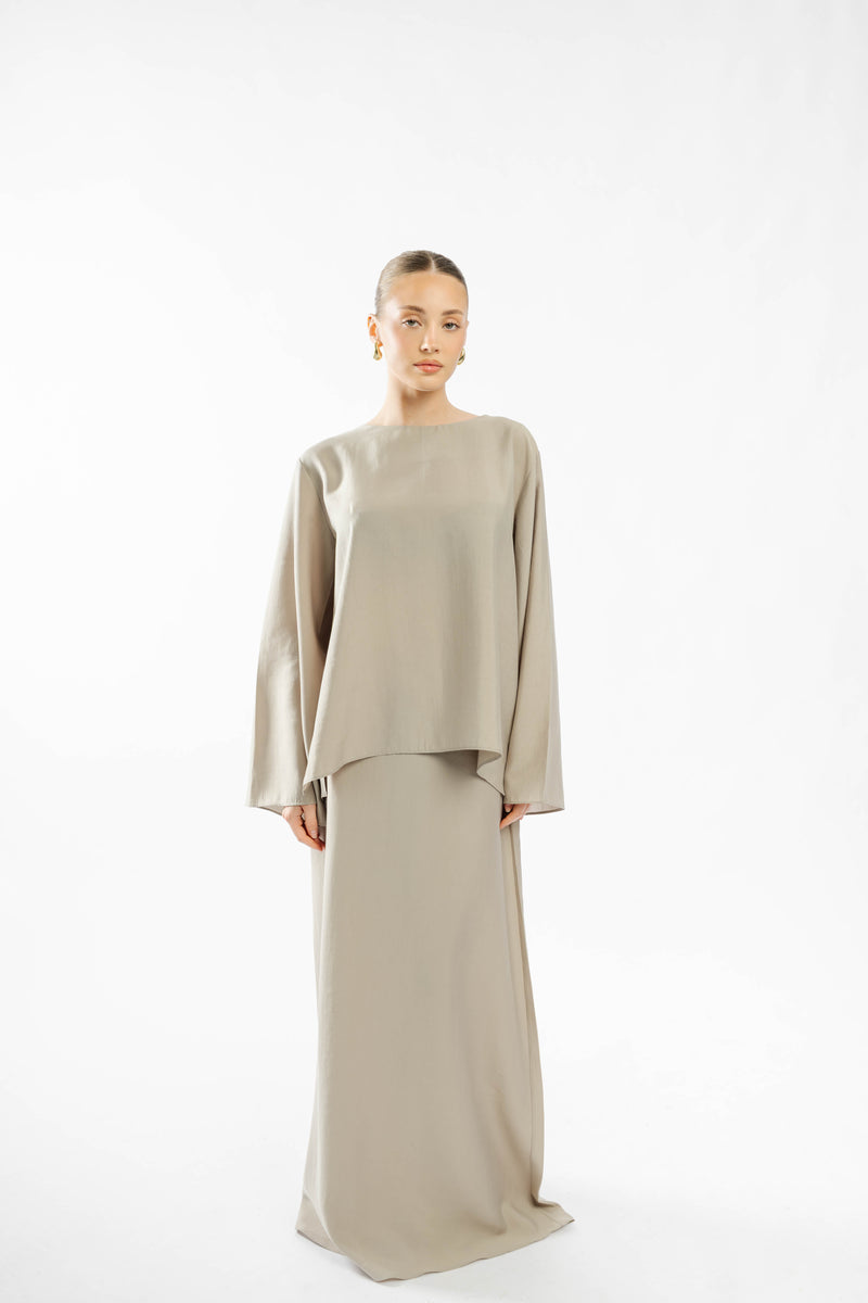 Full front view of model wearing the taupe Naia Set with top and long skirt.